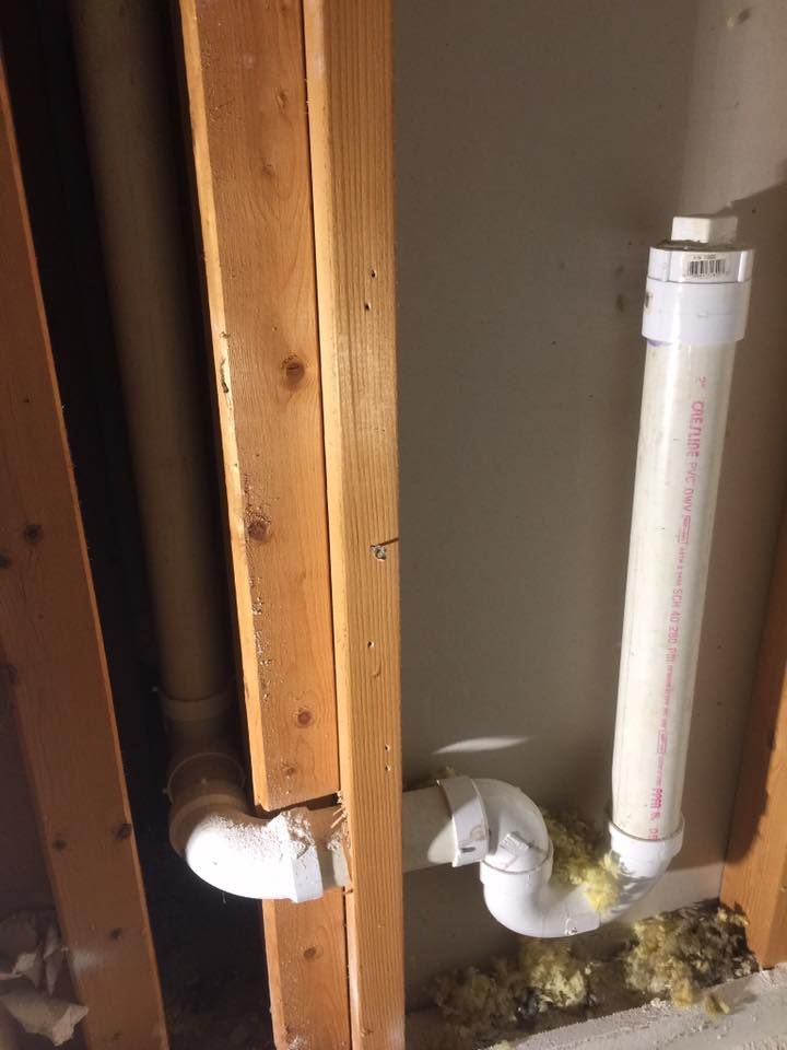 A pipe is hanging from a wooden post in a room.