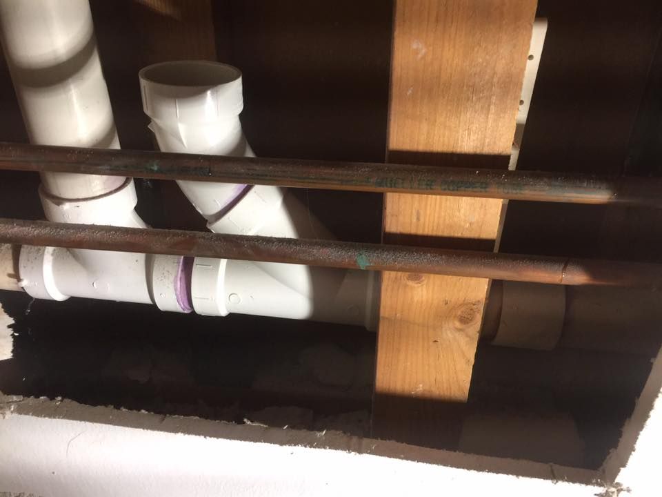 A bunch of pipes are hanging from the ceiling in a room.
