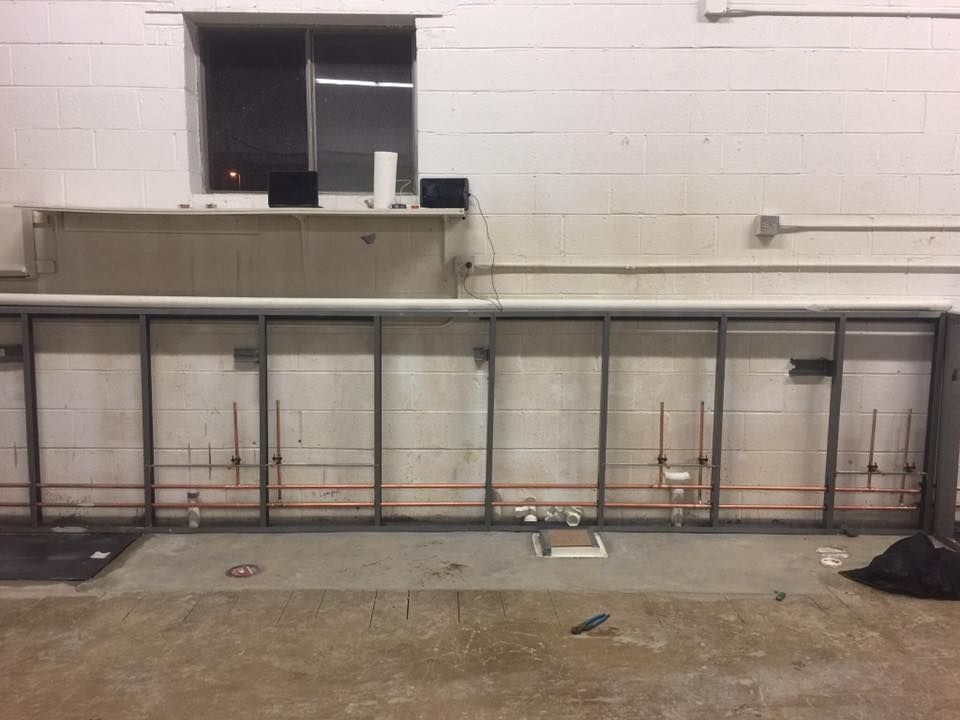 A white brick wall with a metal frame in front of it