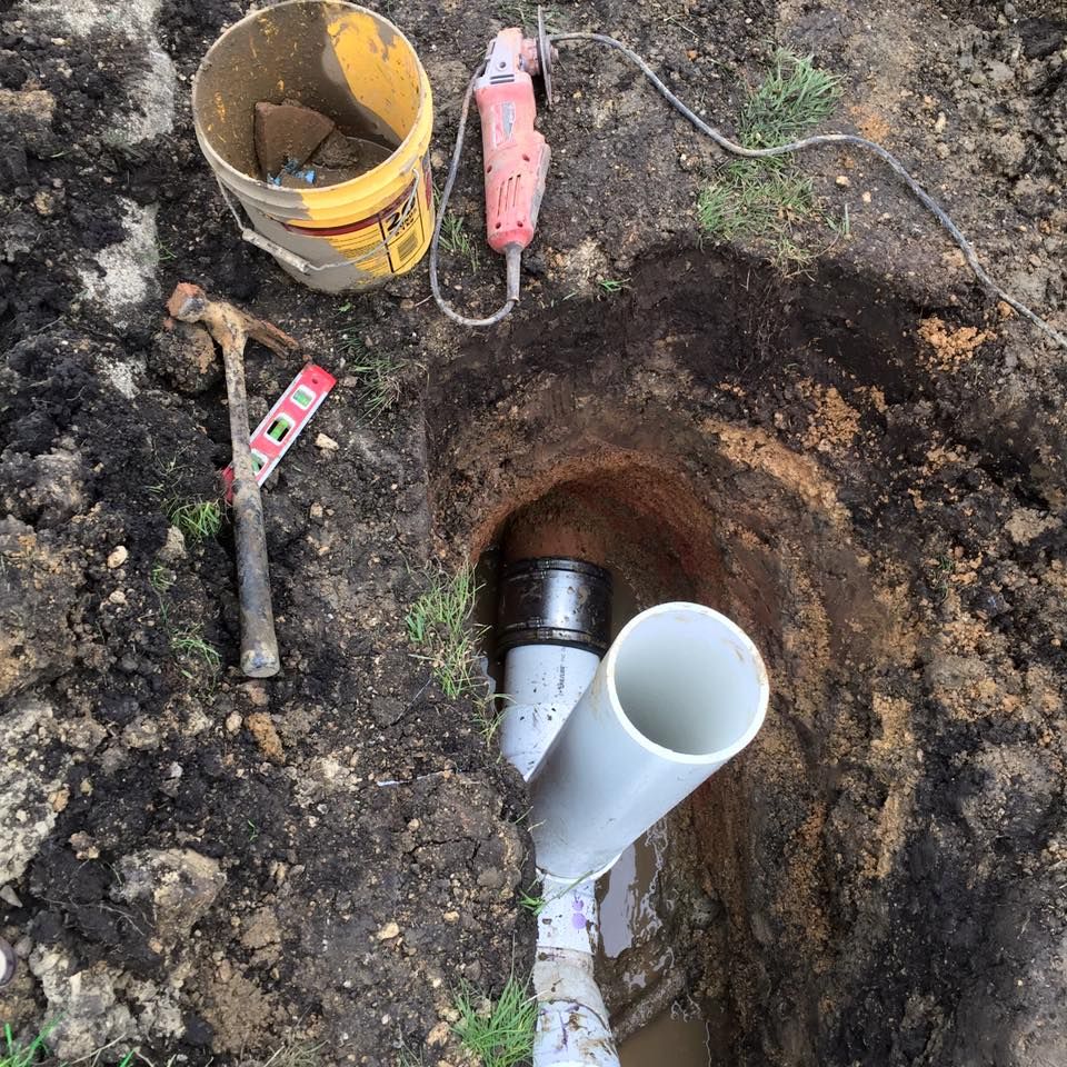 A pipe is being installed in a hole in the ground.