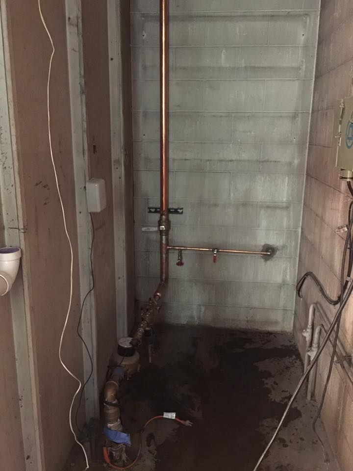 A room with a brick wall and a copper pipe in it.