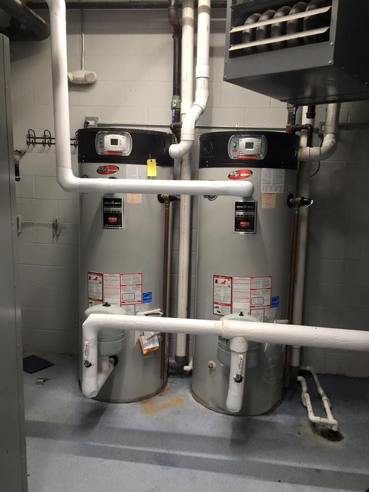 Two water heaters are sitting next to each other in a room