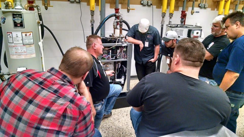 A group of men are standing around a machine in a room.