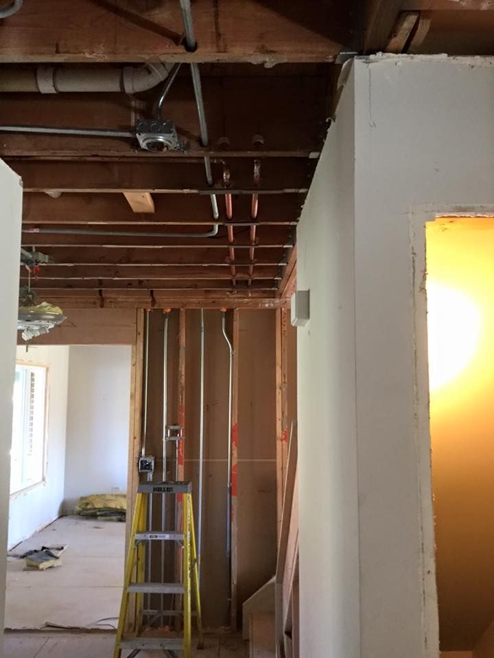 A ladder is sitting in the middle of a room under construction.