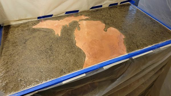 A piece of concrete with a map of michigan on it.