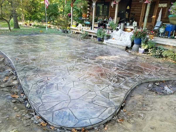 A concrete walkway is being built in front of a log cabin.