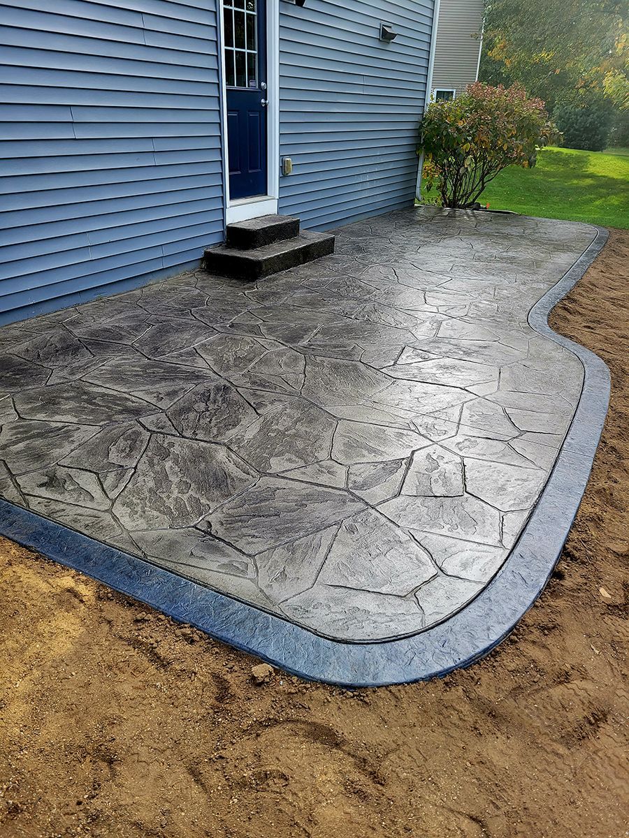 A concrete patio is sitting in front of a blue house.
