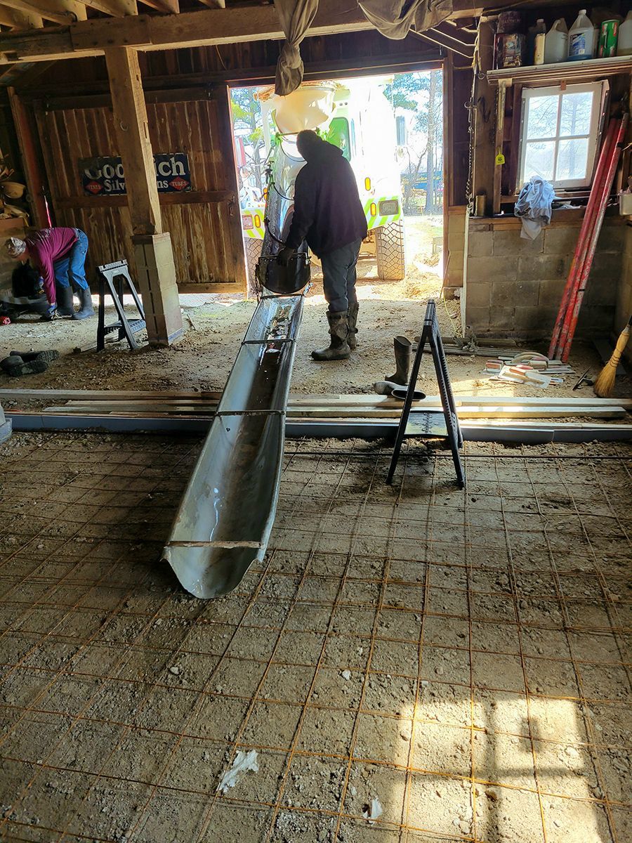 A man is standing next to a large metal pipe in a garage.