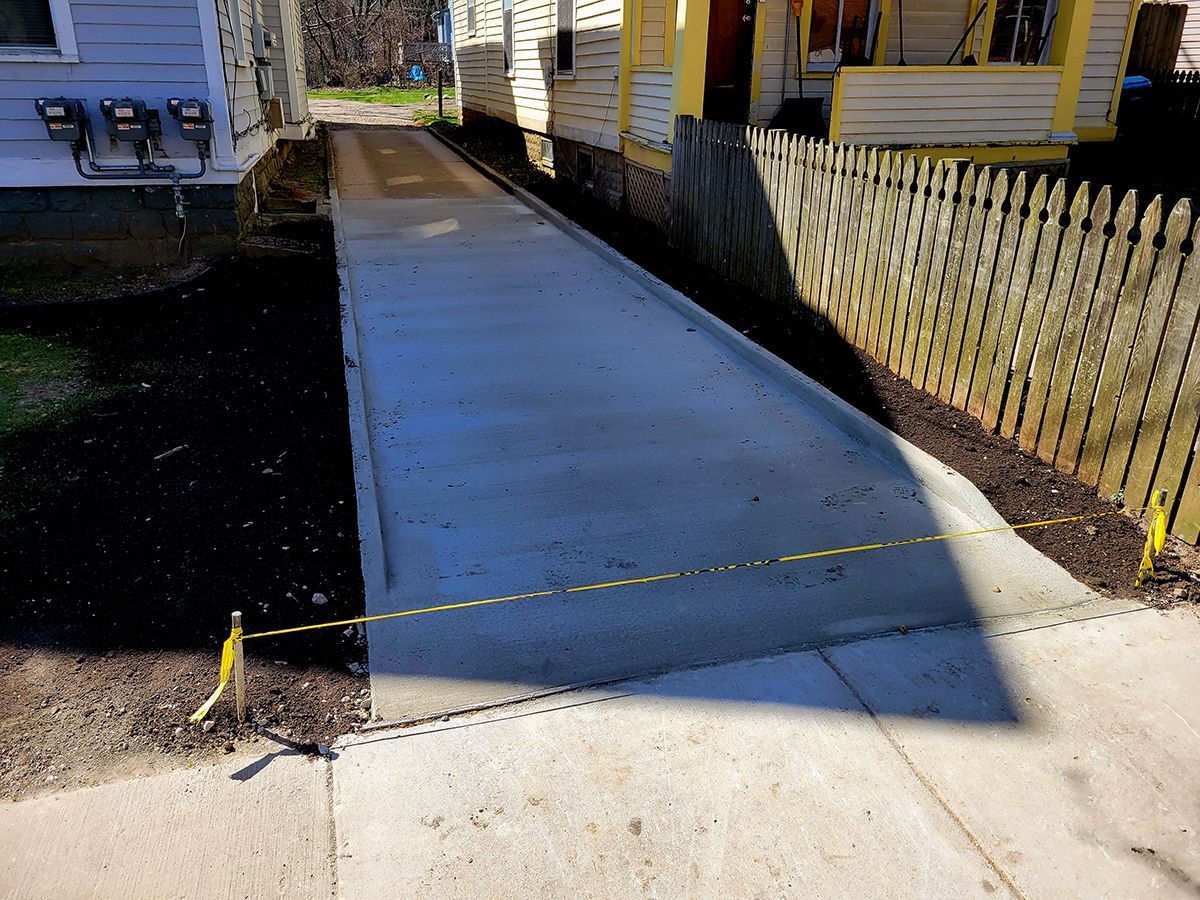 A concrete walkway is being built in front of a house