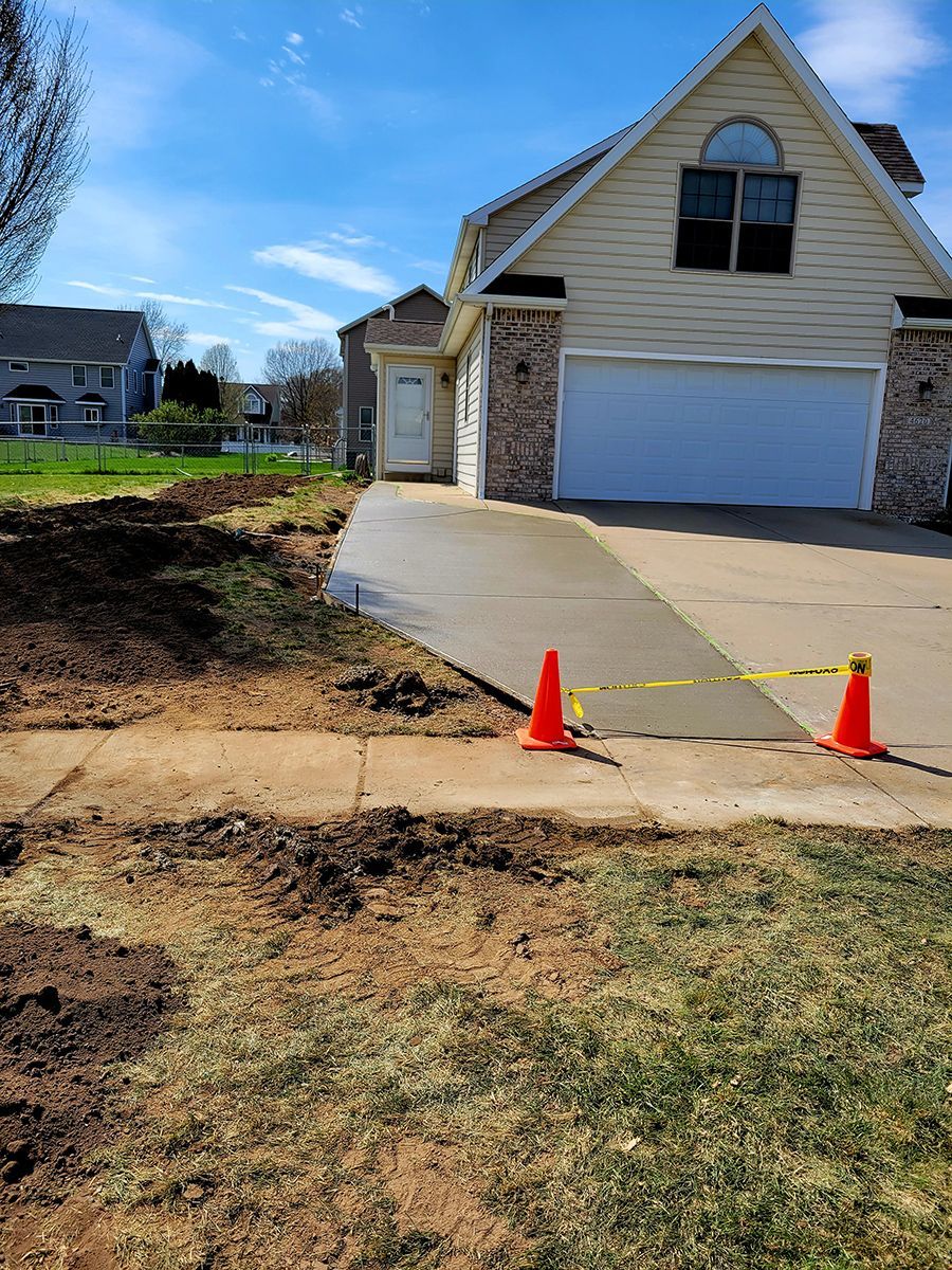 A concrete driveway is being built in front of a house.