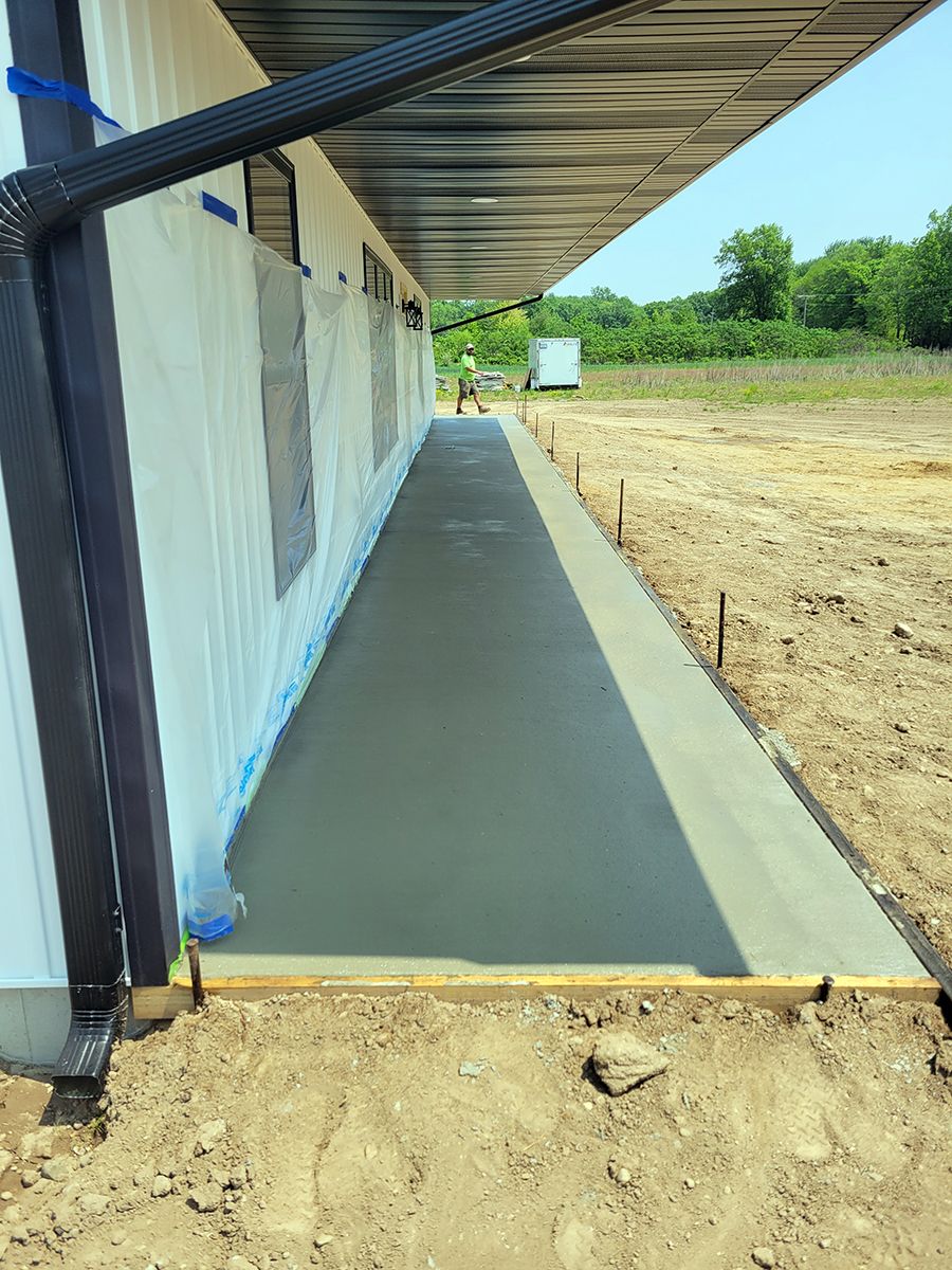 A concrete walkway is being built in front of a building.