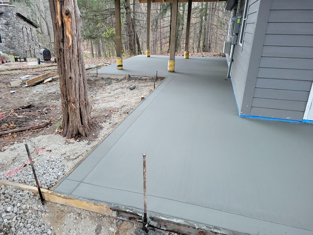 A concrete walkway is being built in front of a house.