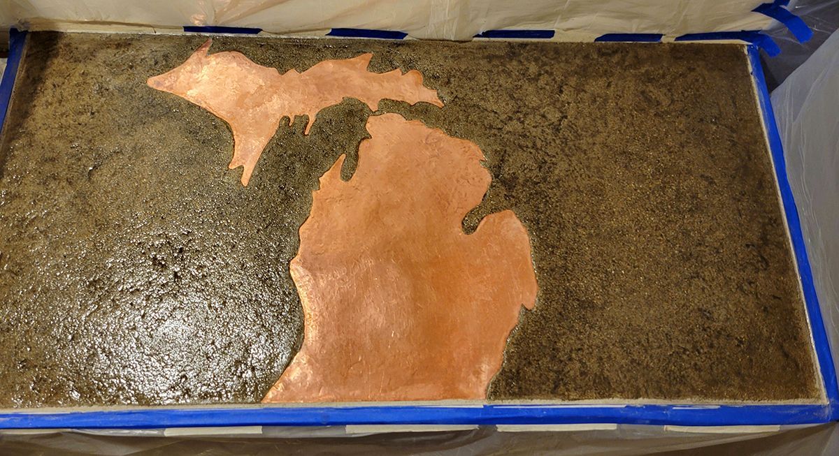 A piece of concrete with a map of michigan on it.