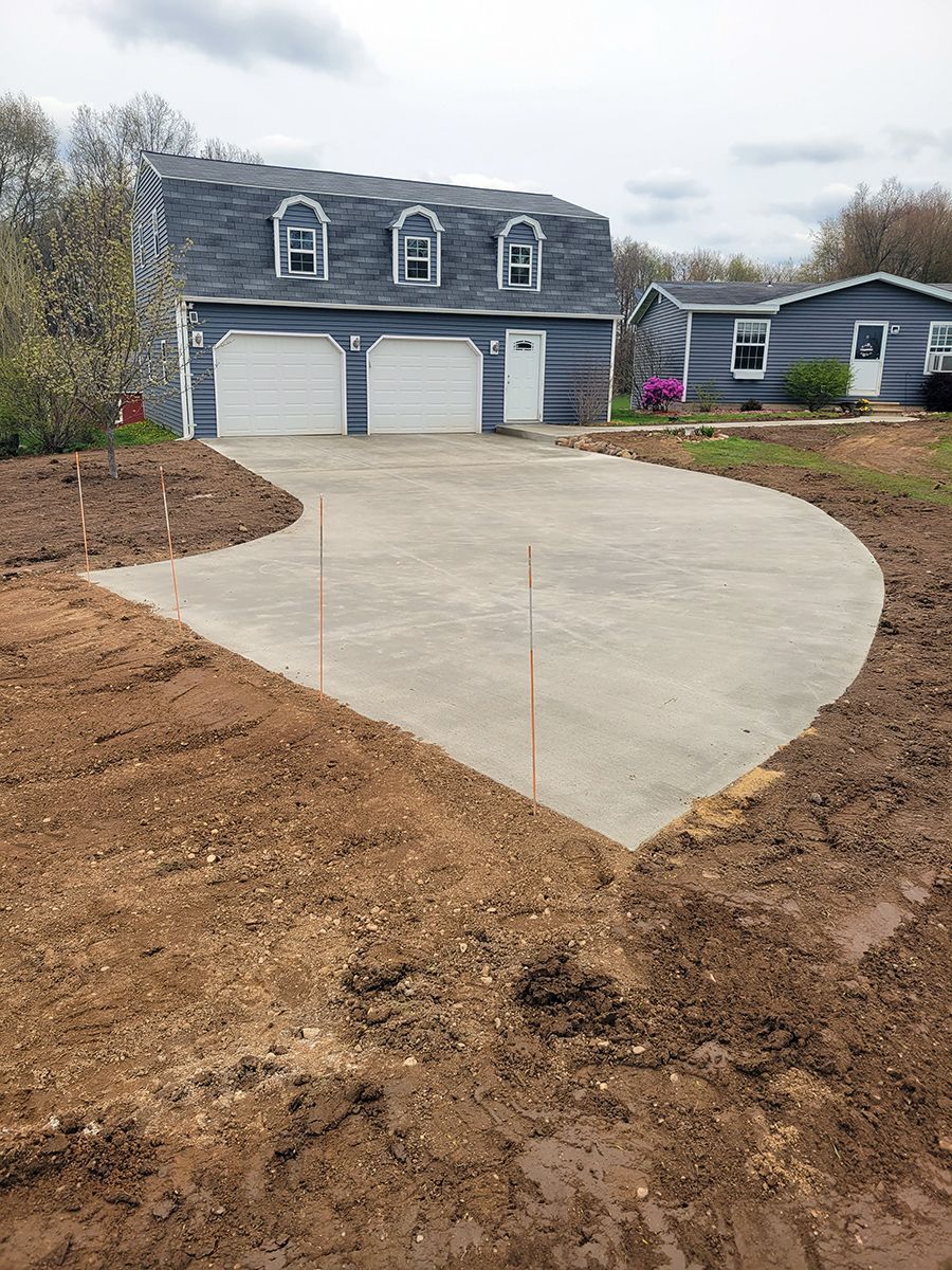 A concrete driveway is being built in front of a house.