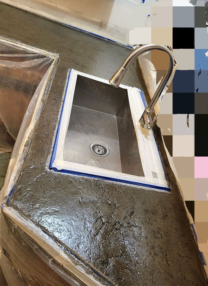 A stainless steel sink is being built in a kitchen