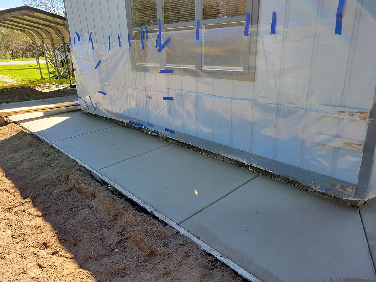 A sidewalk is being built in front of a house.