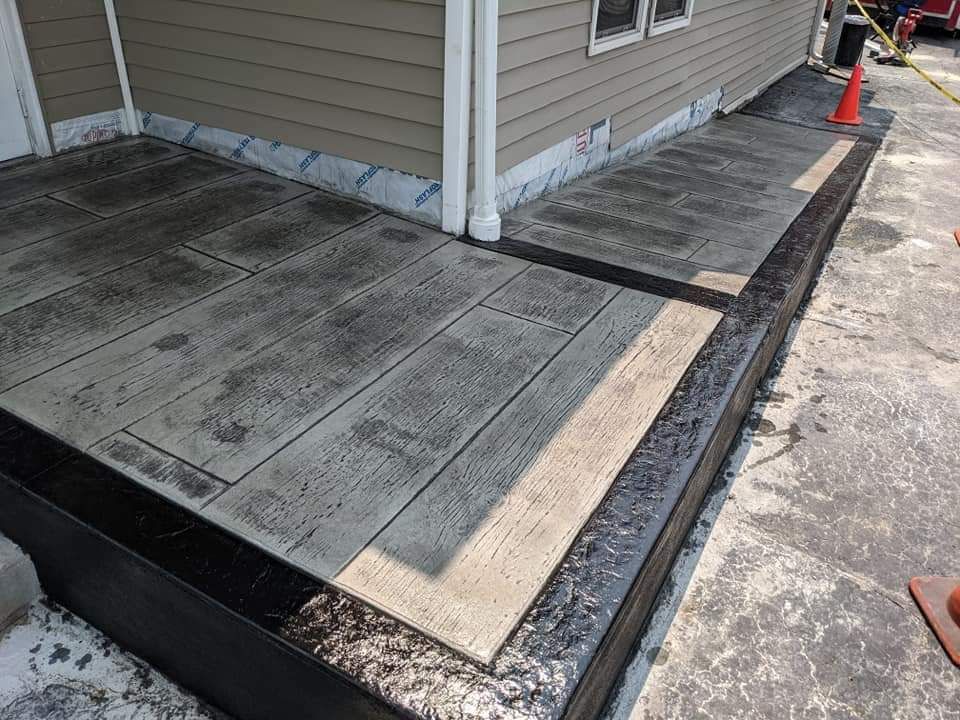 A concrete walkway is being built in front of a house.