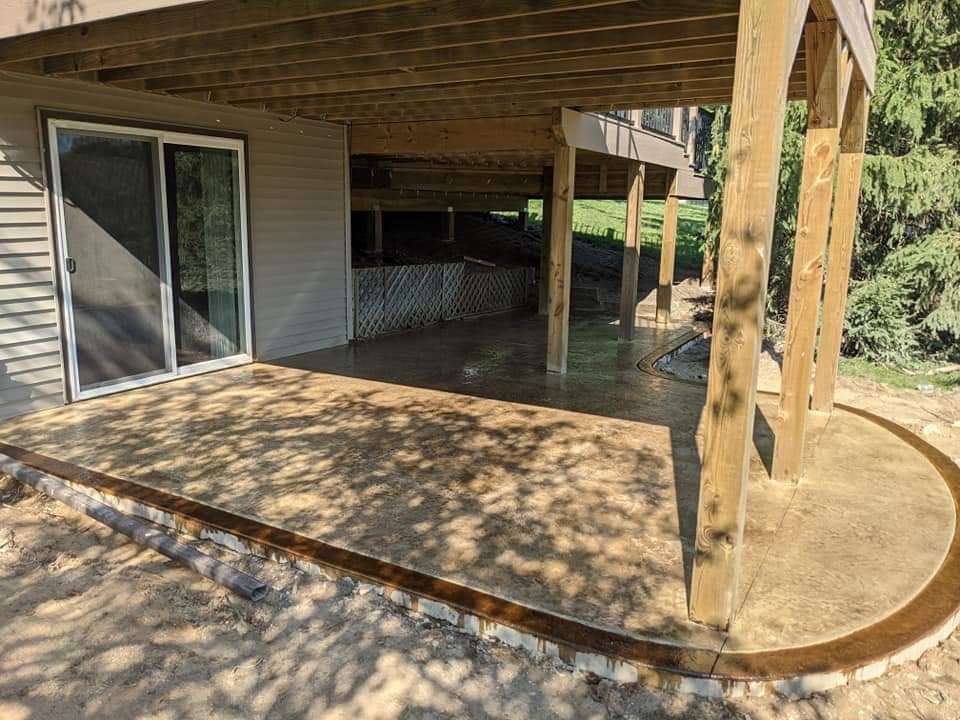 A patio with a wooden deck and a sliding glass door.