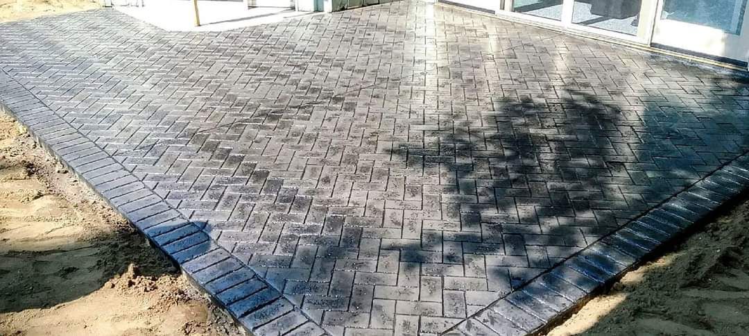 A large piece of concrete is sitting on top of a sandy surface.