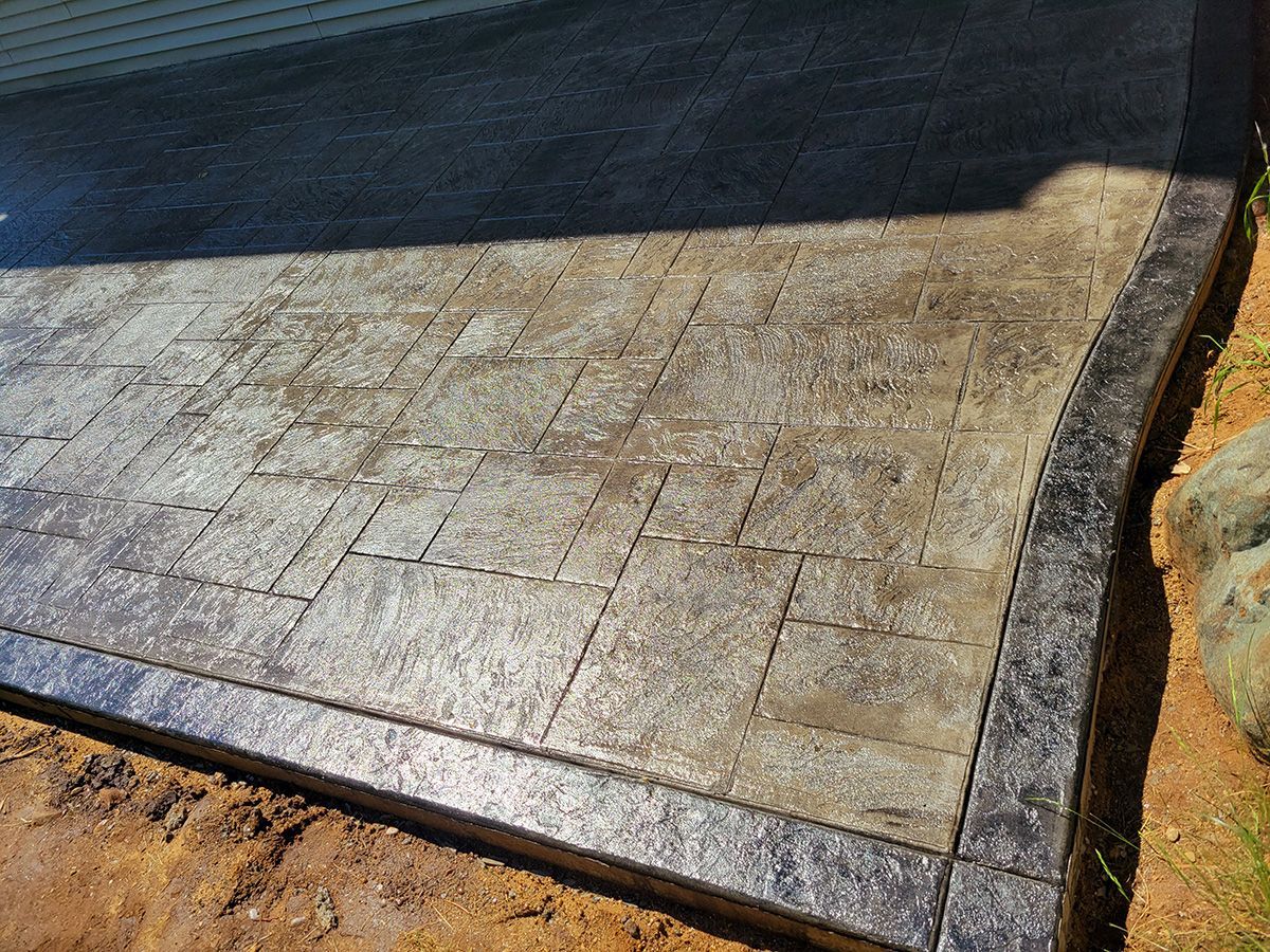 A concrete walkway is being built next to a pool.