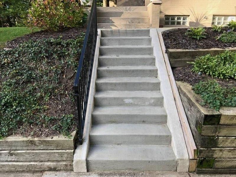 A set of concrete stairs leading up to a house.