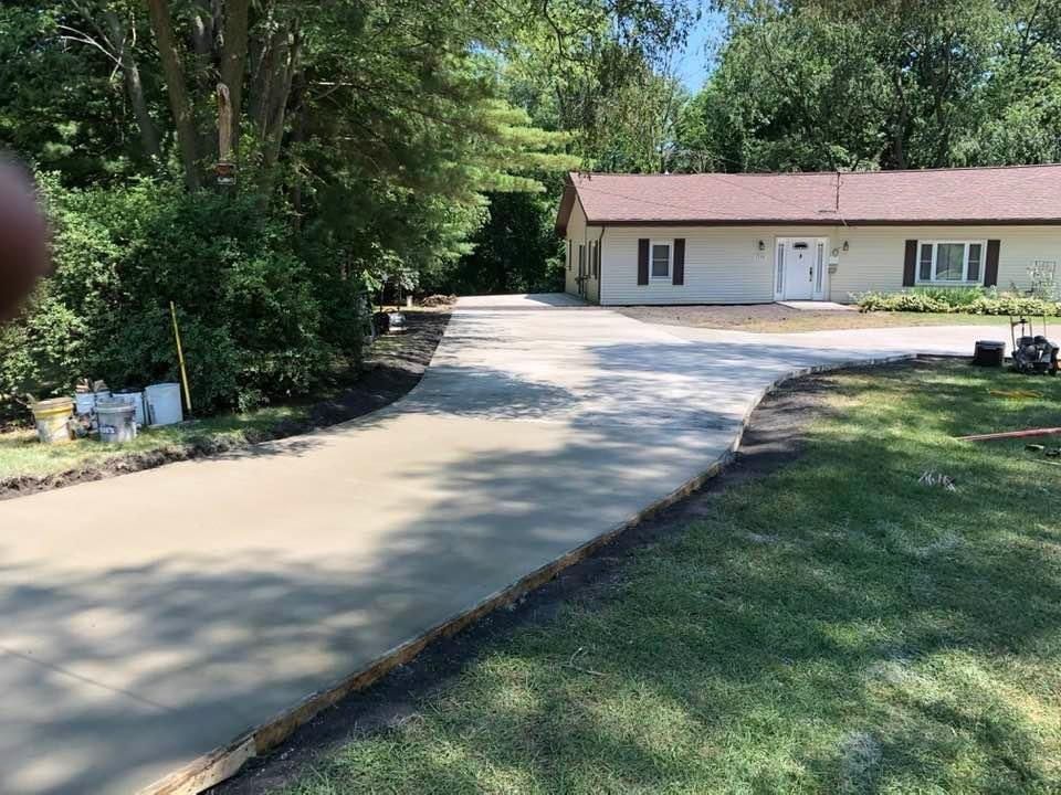 A concrete driveway is being built in front of a house.