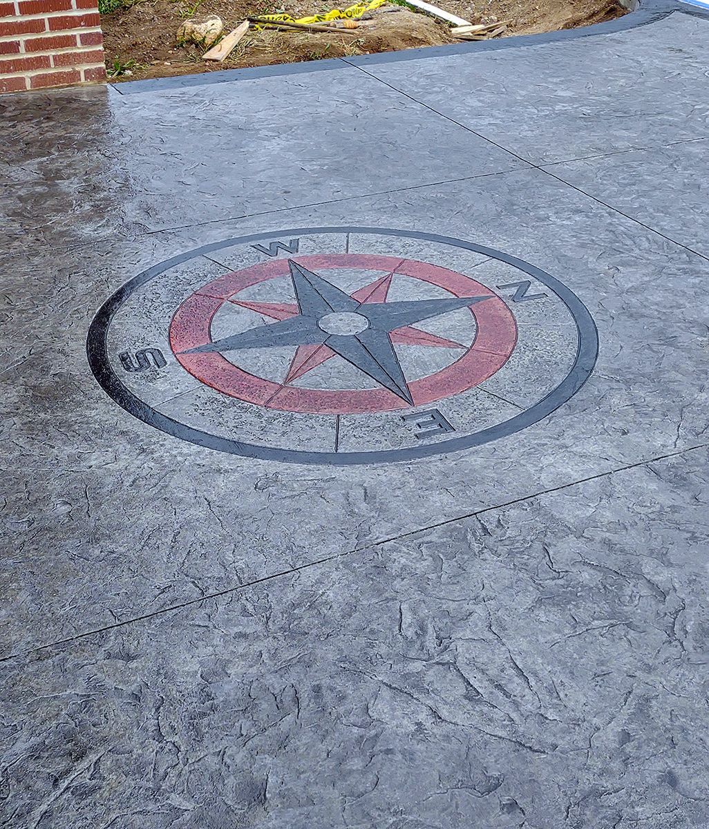 A concrete driveway with a compass on it