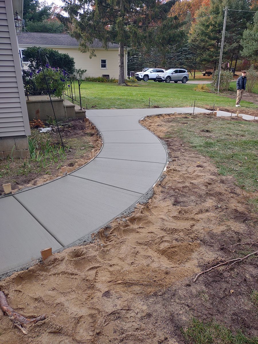A concrete walkway is being built in front of a house.