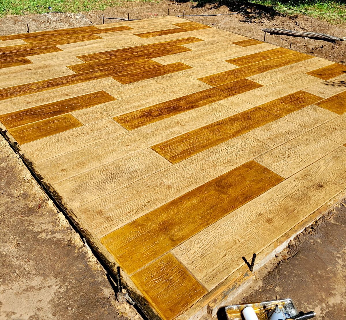 A large piece of wood is sitting on top of a concrete surface.