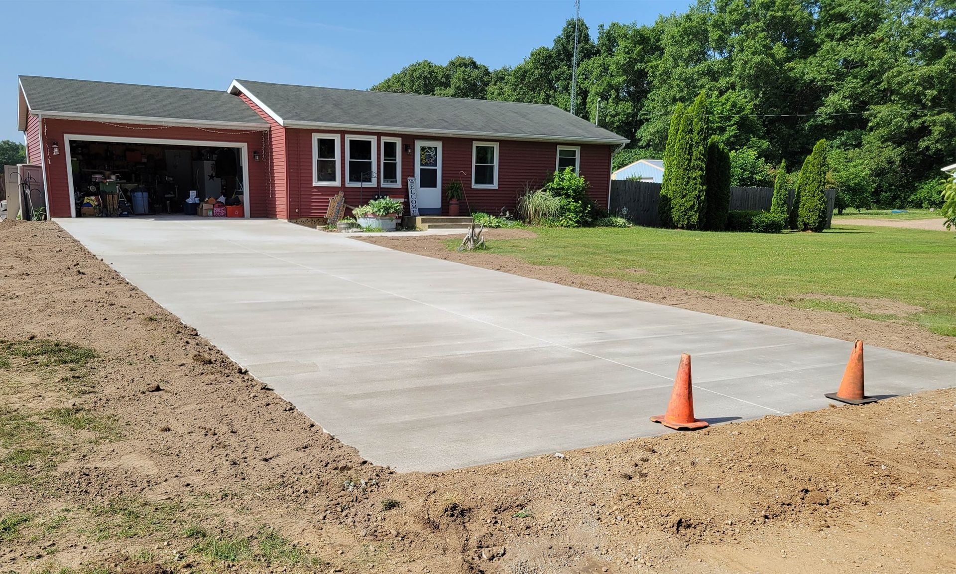 A brick house with a concrete driveway leading to it