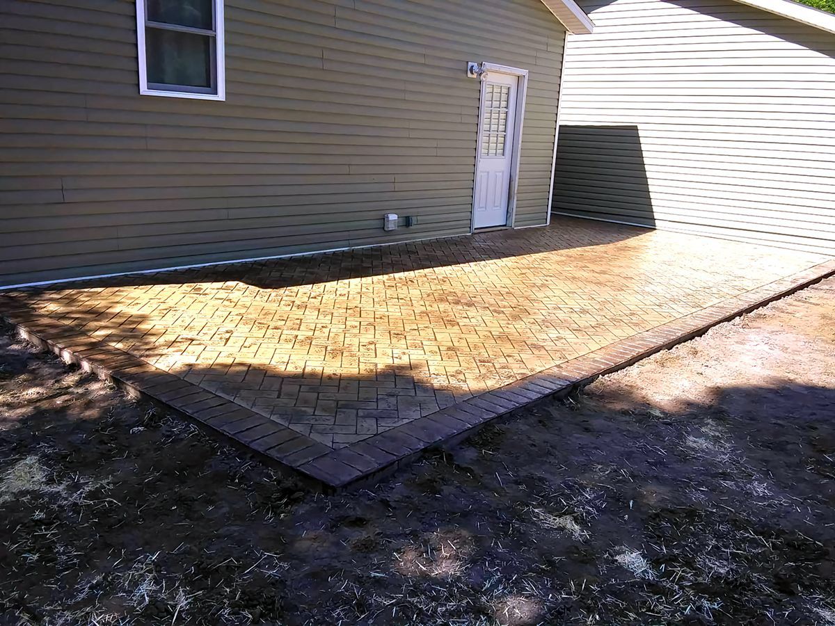A brick walkway is being built in front of a house.