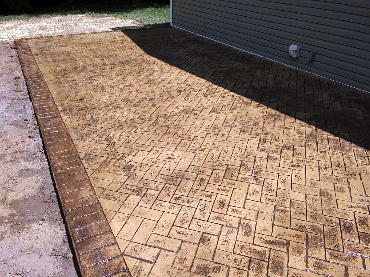A brick walkway is being built in front of a house.