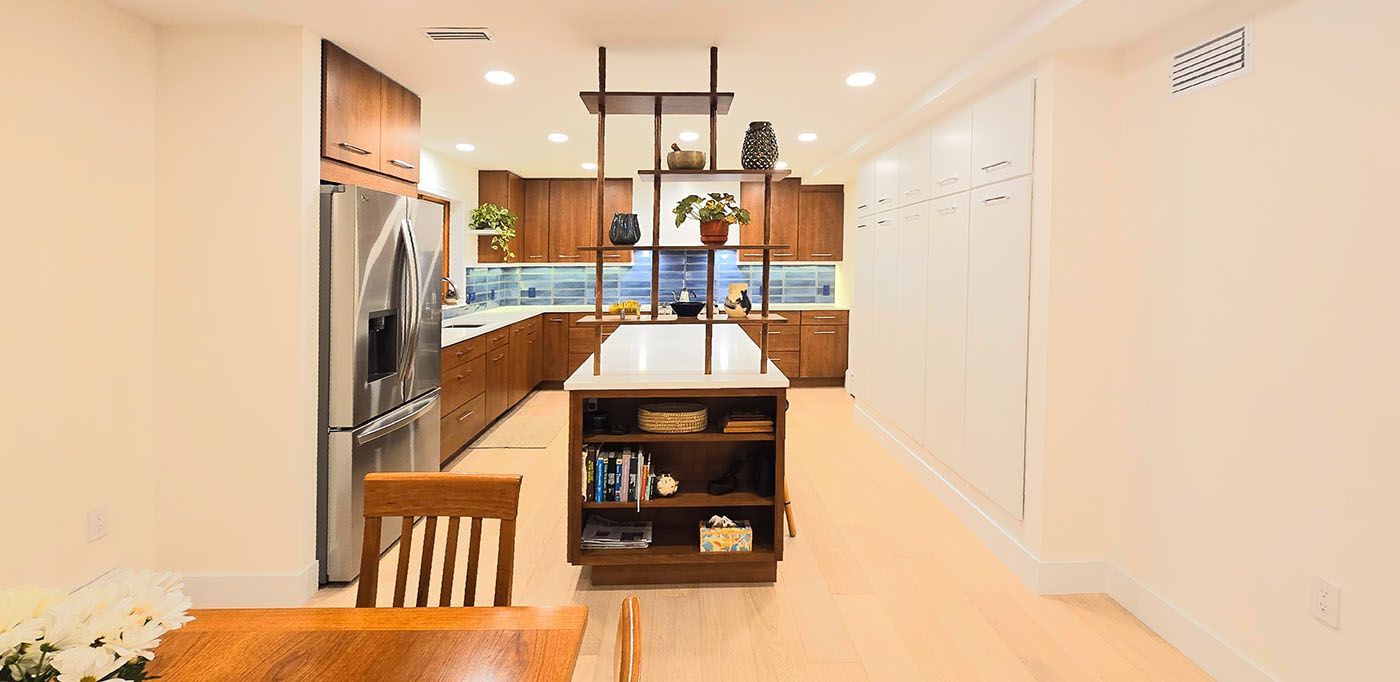 A kitchen with a large island in the middle and a dining table and chairs