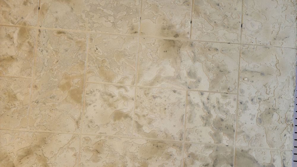 Beige tiled wall with a marbled texture.