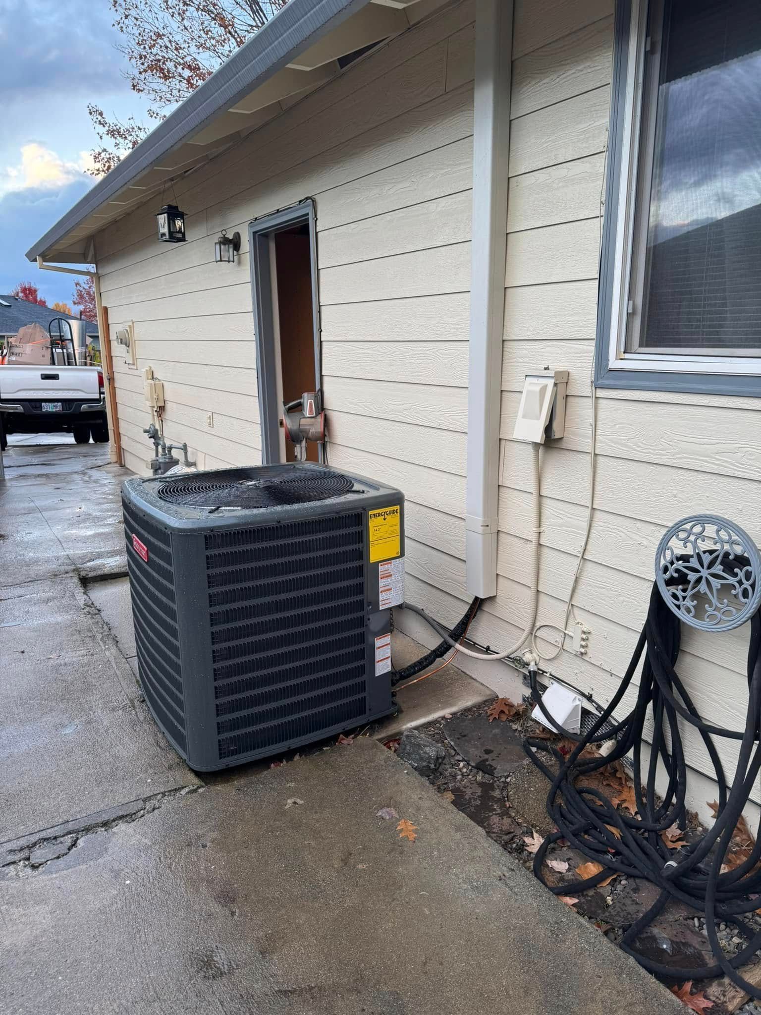 An air conditioner is sitting on the side of a house.