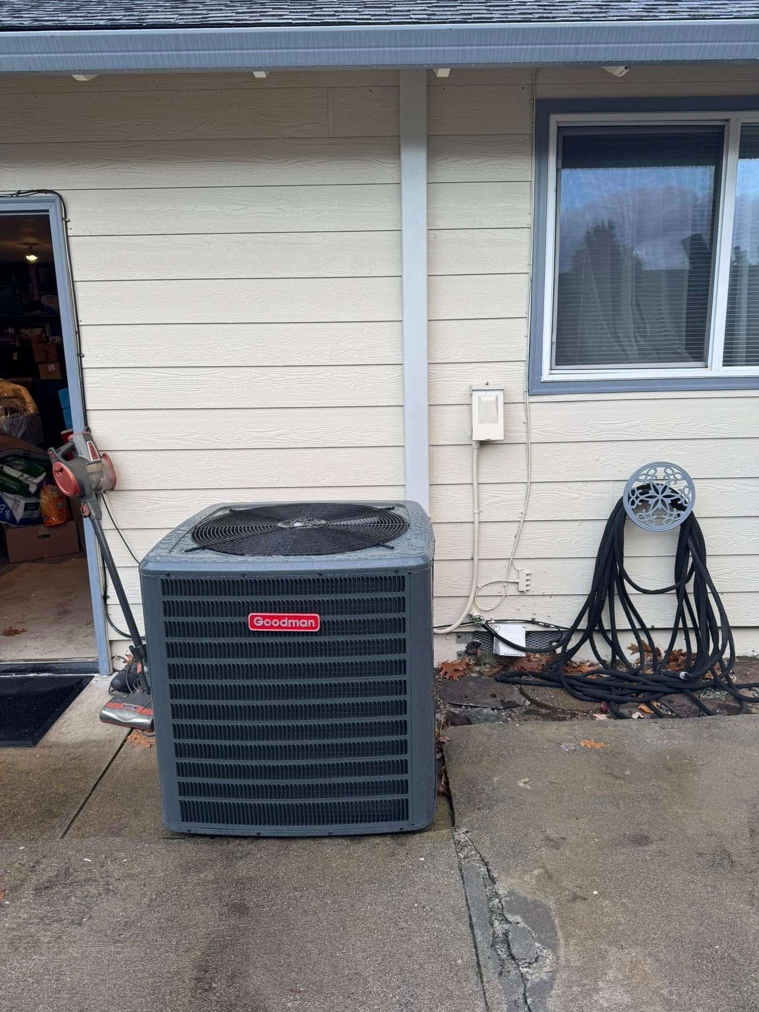 An air conditioner is sitting on the side of a house next to a window.