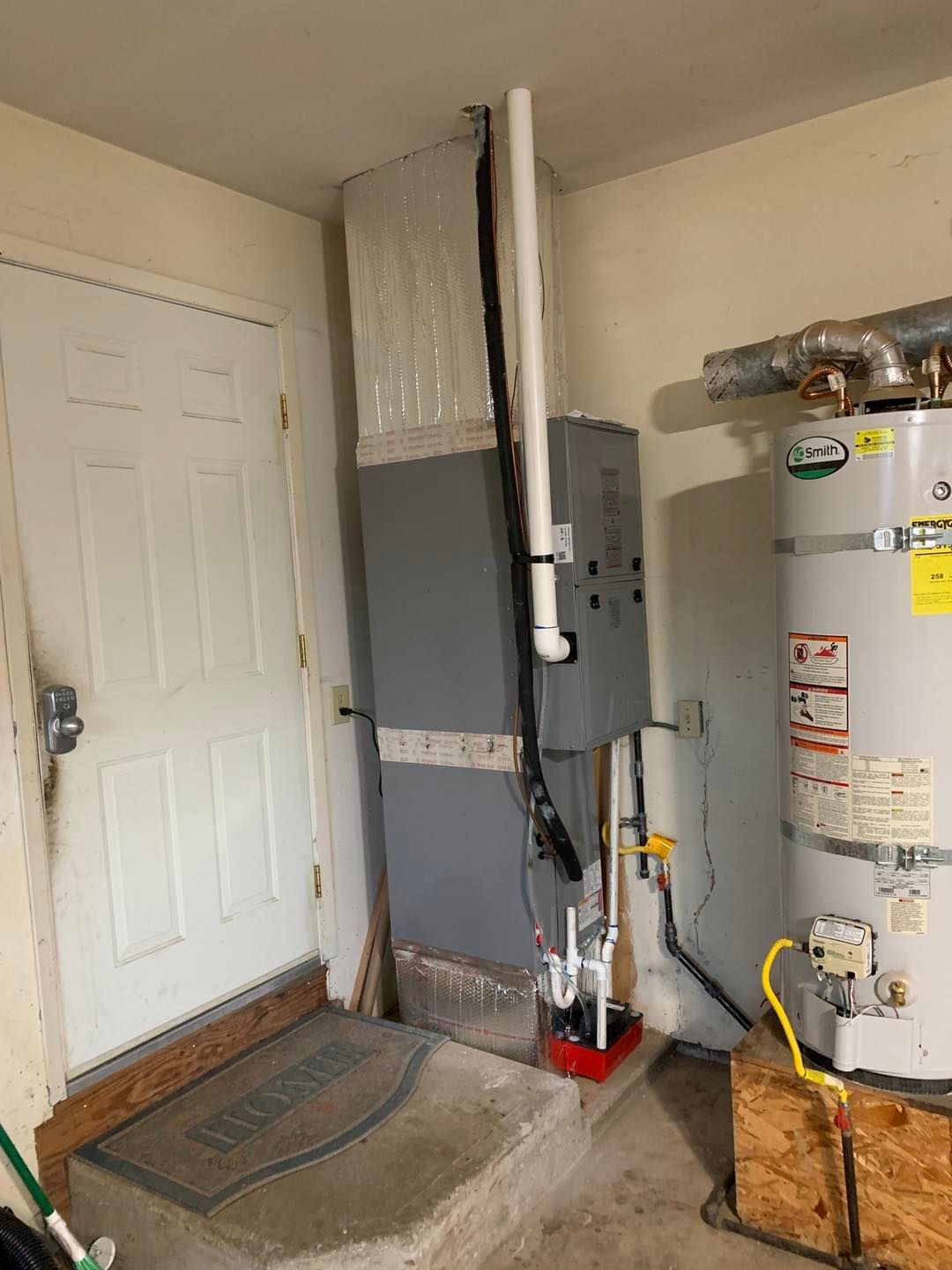 A room with a water heater and a furnace in it.