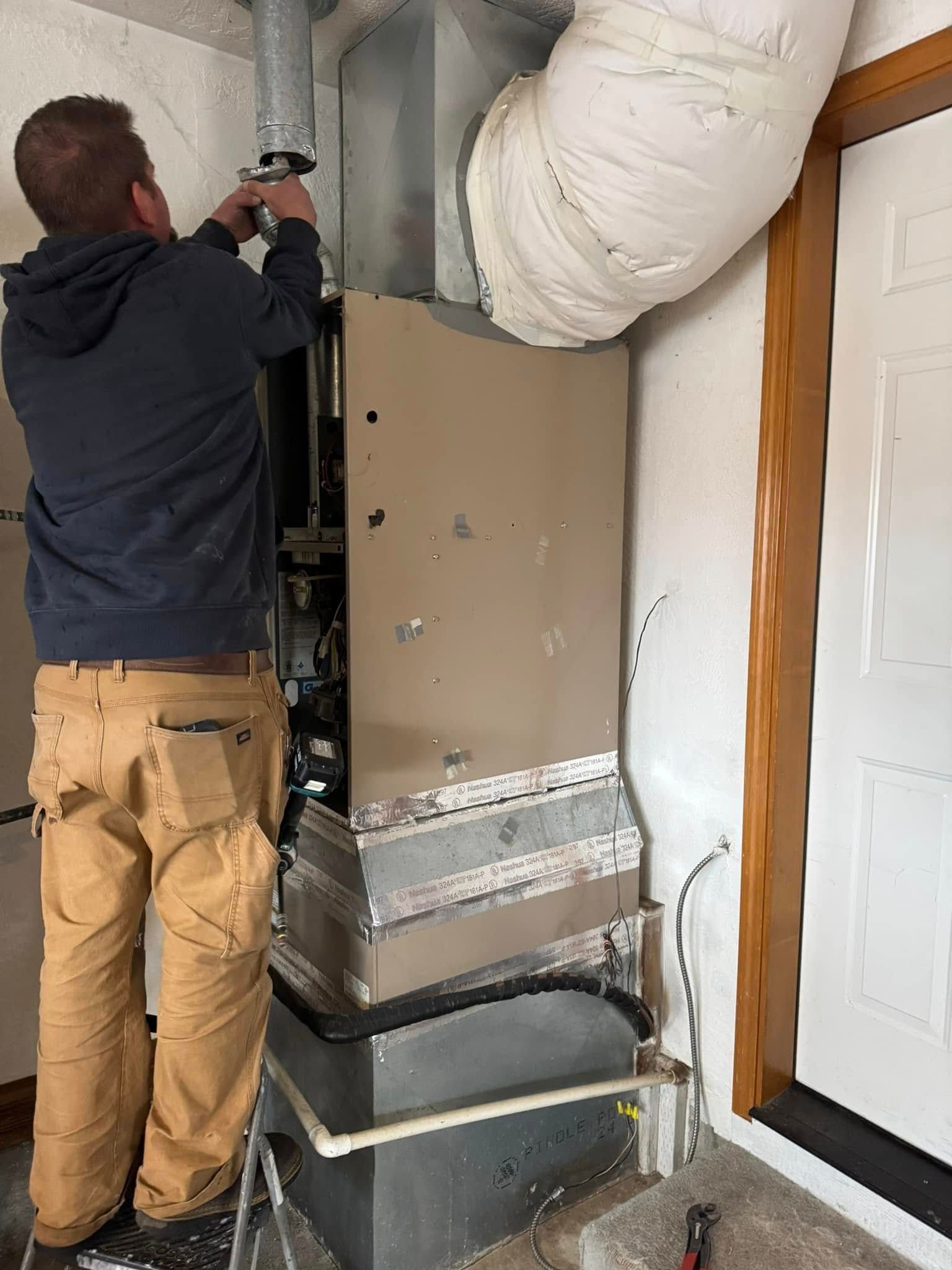 A man is working on an air conditioner in a room.