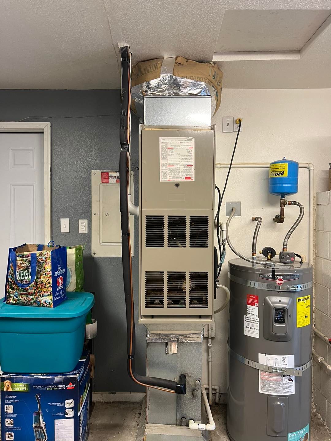 A room with a heater and a water heater in it.