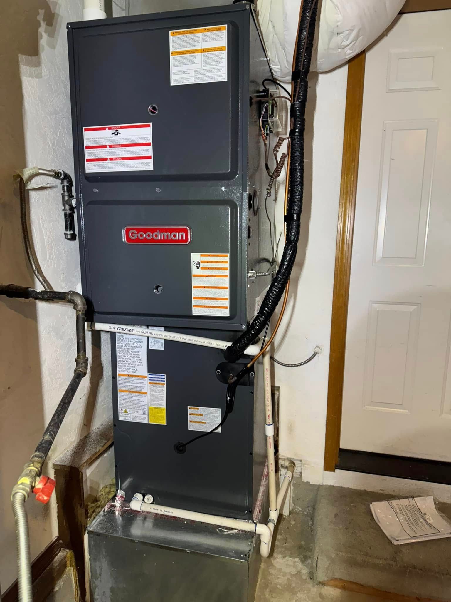 An air conditioner is sitting in a basement next to a door.