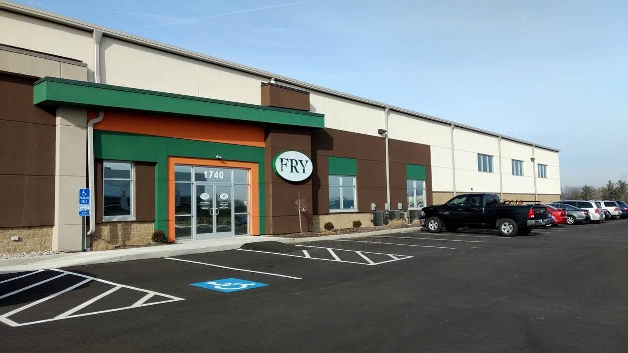 Exterior view of a commercial building with green and orange accents, labeled 