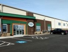 Fry restaurant exterior with a green and brown facade, accessible parking spot, and a black truck parked.