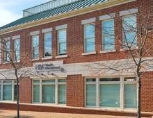 Brick building with large windows and a sign that reads 