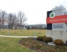 Sign for Scarlet Oaks retirement community in front of a green lawn and trees.