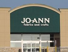Joann Fabrics and Crafts store entrance with green signage and a white door.