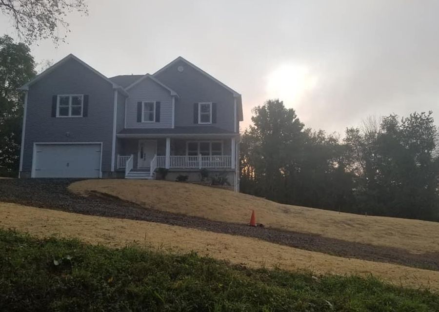 a large house is sitting on top of a grassy hill