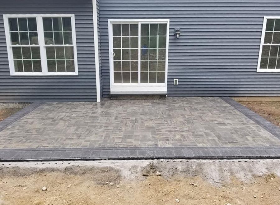 there is a patio in front of the house with sliding glass doors