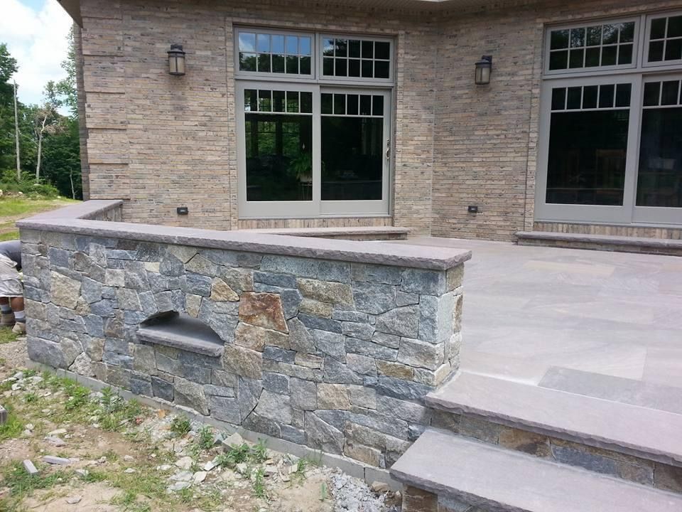 a brick house with a stone wall and steps