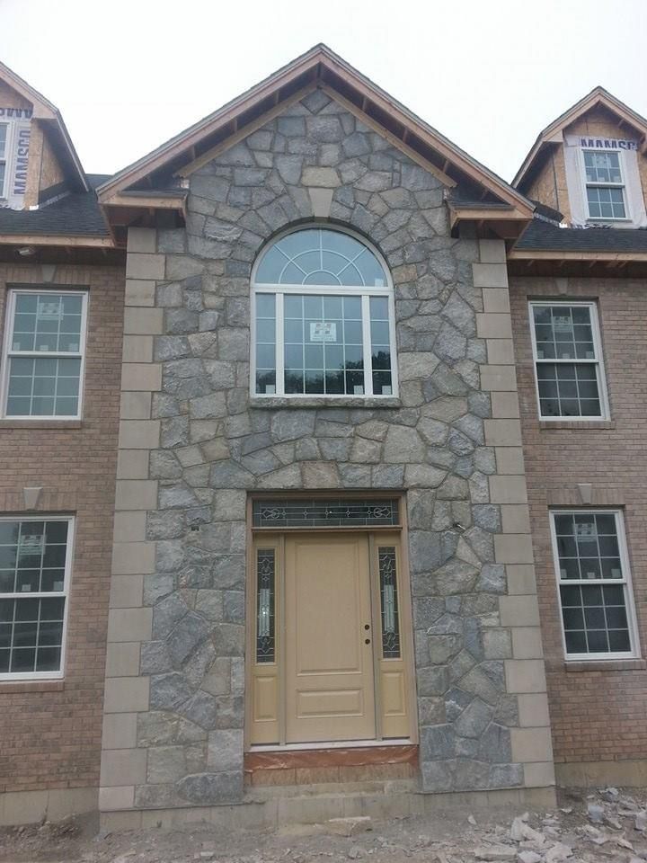 a brick house with a stone facade and a door