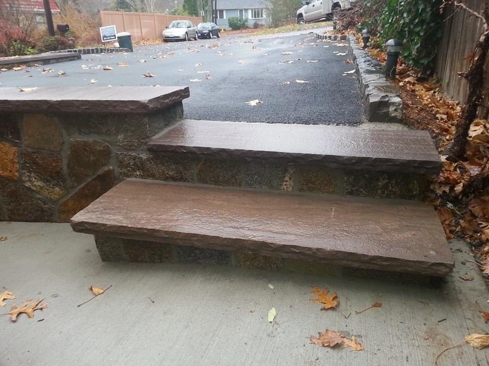 a set of stone steps leading up to a driveway